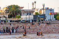 People by the flooded river, Medina